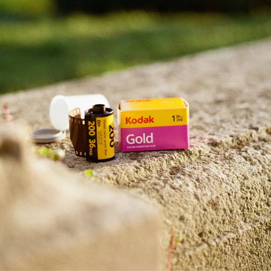 Kodak Gold Verpackung, Filmdose und 35mm ilm auf Steinmauer. Aufgenommen mit Kodak Gold.