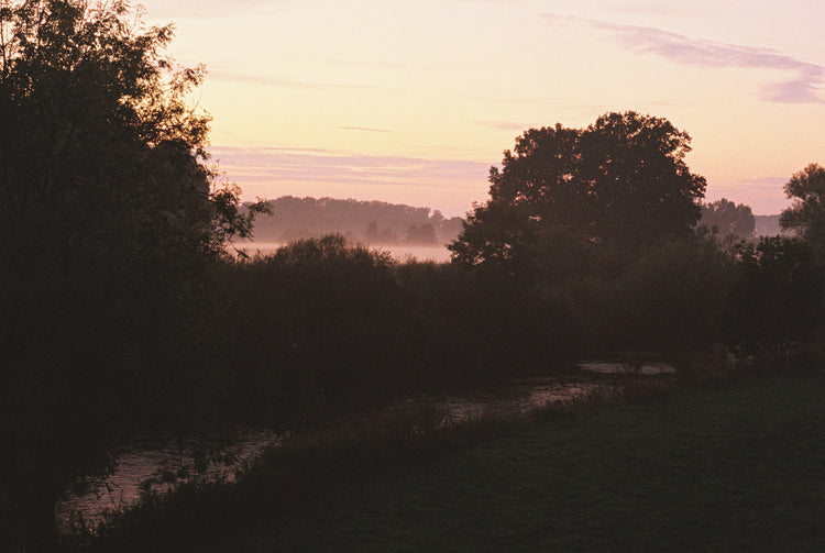 Sonnenuntergang mit rotem Himmel und Fluss im Vordergrund